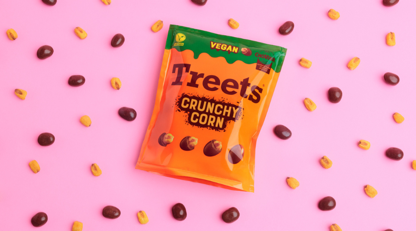 Treets vegan Crunchy Corn Produkt platziert zwischen Korn und Schokolade